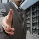 businessmen offer hand shake in a technology data center