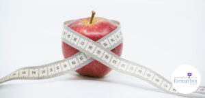 Pomme qui se serre la ceinture pour illustrer le budget formation 2026 au régime sec